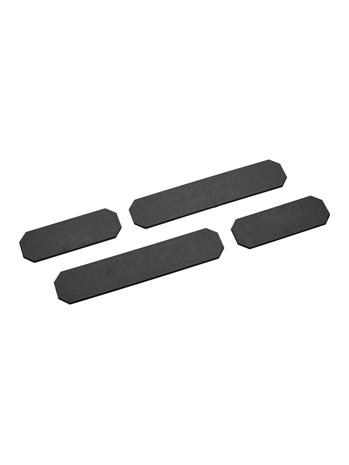 Das Bild zeigt vier schwarze Ersatz-Trennstege in unterschiedlichen Größen. Die Stege haben eine rechteckige Form mit abgeschrägten Ecken und sind flach gestaltet.