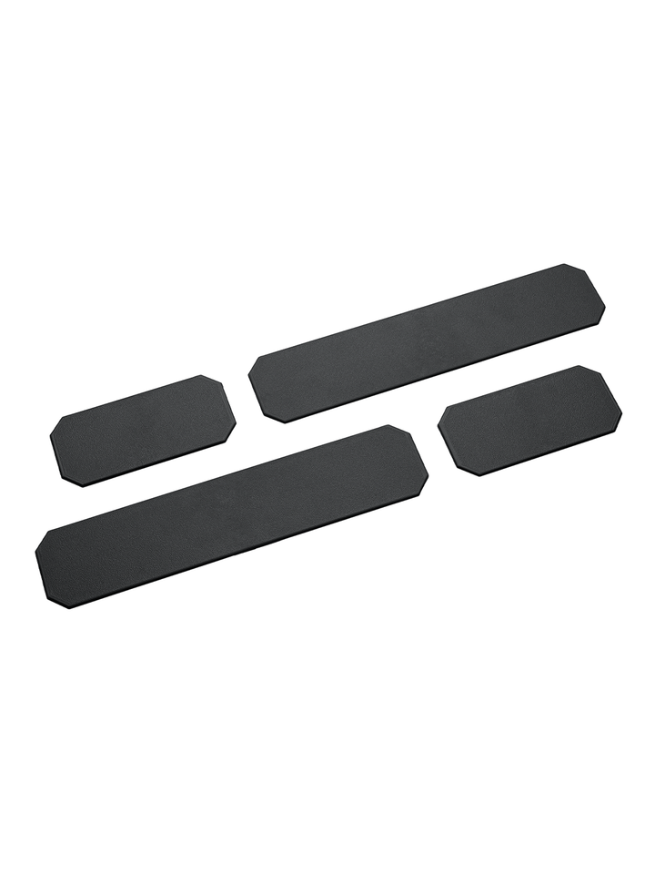 Das Bild zeigt vier schwarze Ersatz-Trennstege in unterschiedlichen Größen. Die Stege haben eine rechteckige Form mit abgeschrägten Ecken und sind flach gestaltet.
