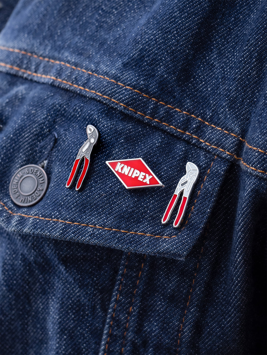 Set aus drei Knipex-Pins auf Jeans Stoff angebracht. Die Pins zeigen zwei Werkzeuge, eine Wasserpumpenzange und einen Zangenschlüssel, sowie das rote Knipex-Logo in Diamantform. 